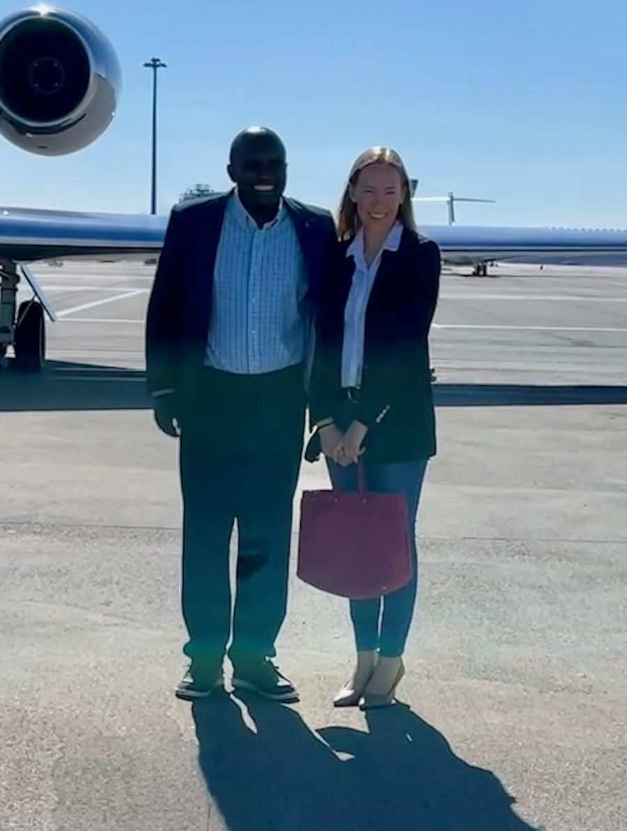 Julius Mwale and Kaila Knox Mwale posing in front of a private jet